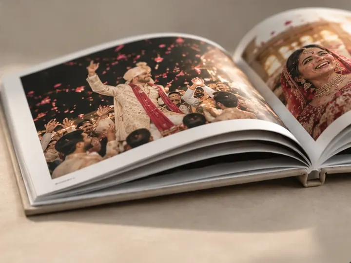 Photobook open on a baraat celebration with flower petals